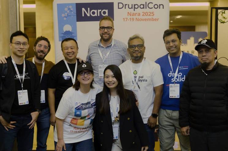 The volunteers of the community booth with funder of Drupal Dries